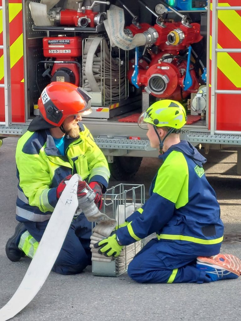 Kuvassa Sallan VPK:n hälytysosastolainen ja nuoriso-osastolainen käsittelemässä letkua yhteisharjoituksissa. Kuvaaja: Outi Kunnamo.