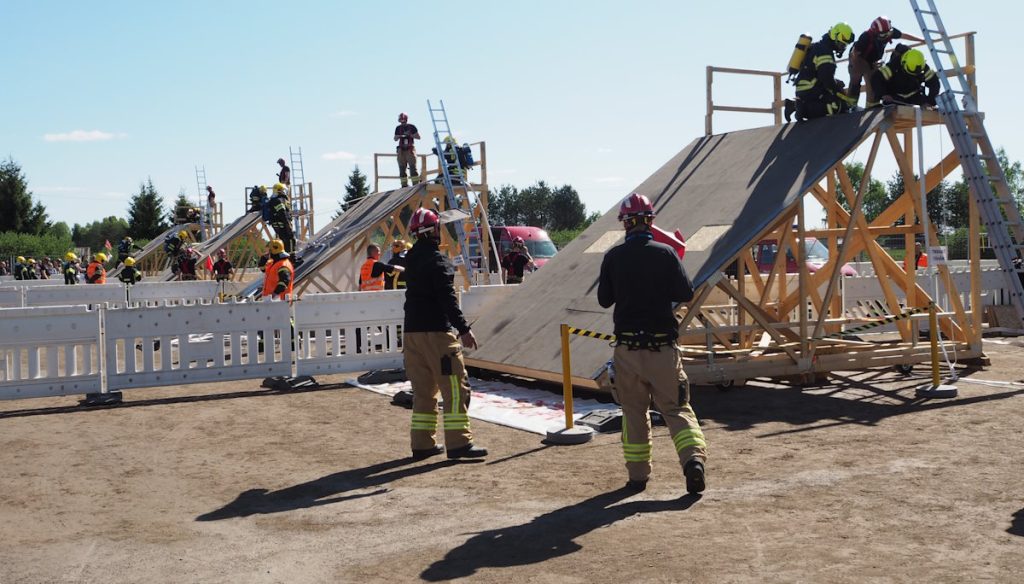 Kalusto-osiossa hiekkakentälle on asetettu vierekkäin neljä puurakenteista korkeaa ramppia, joiden oikealla puolella on tikkaat. Kuvassa pelastajajoukkueet suorittavat tehtävää rampin päällä. 